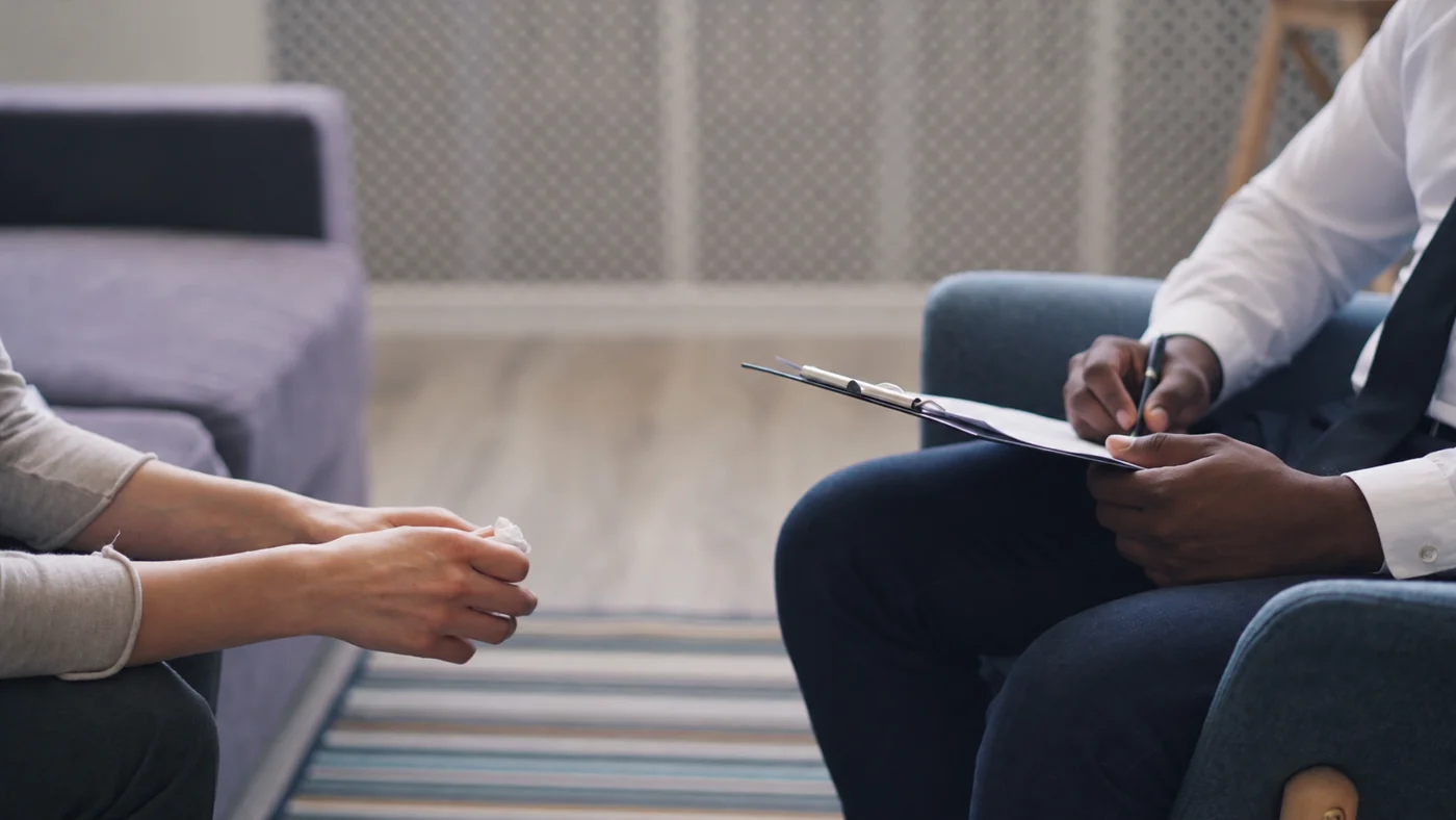 A counselor taking notes while listening to a client